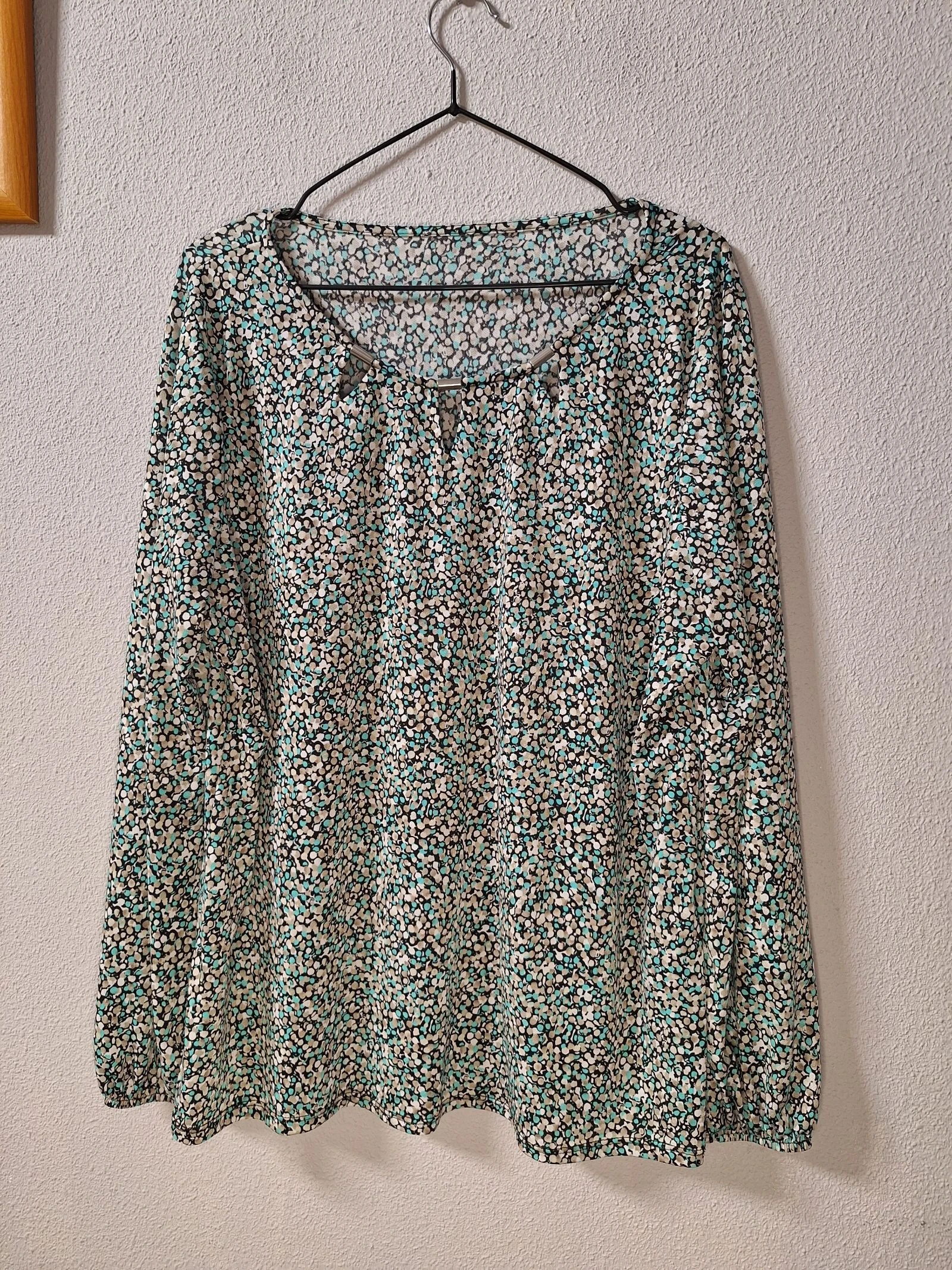 Blusa estampada en tonos beige, negro y turquesa con cuello original